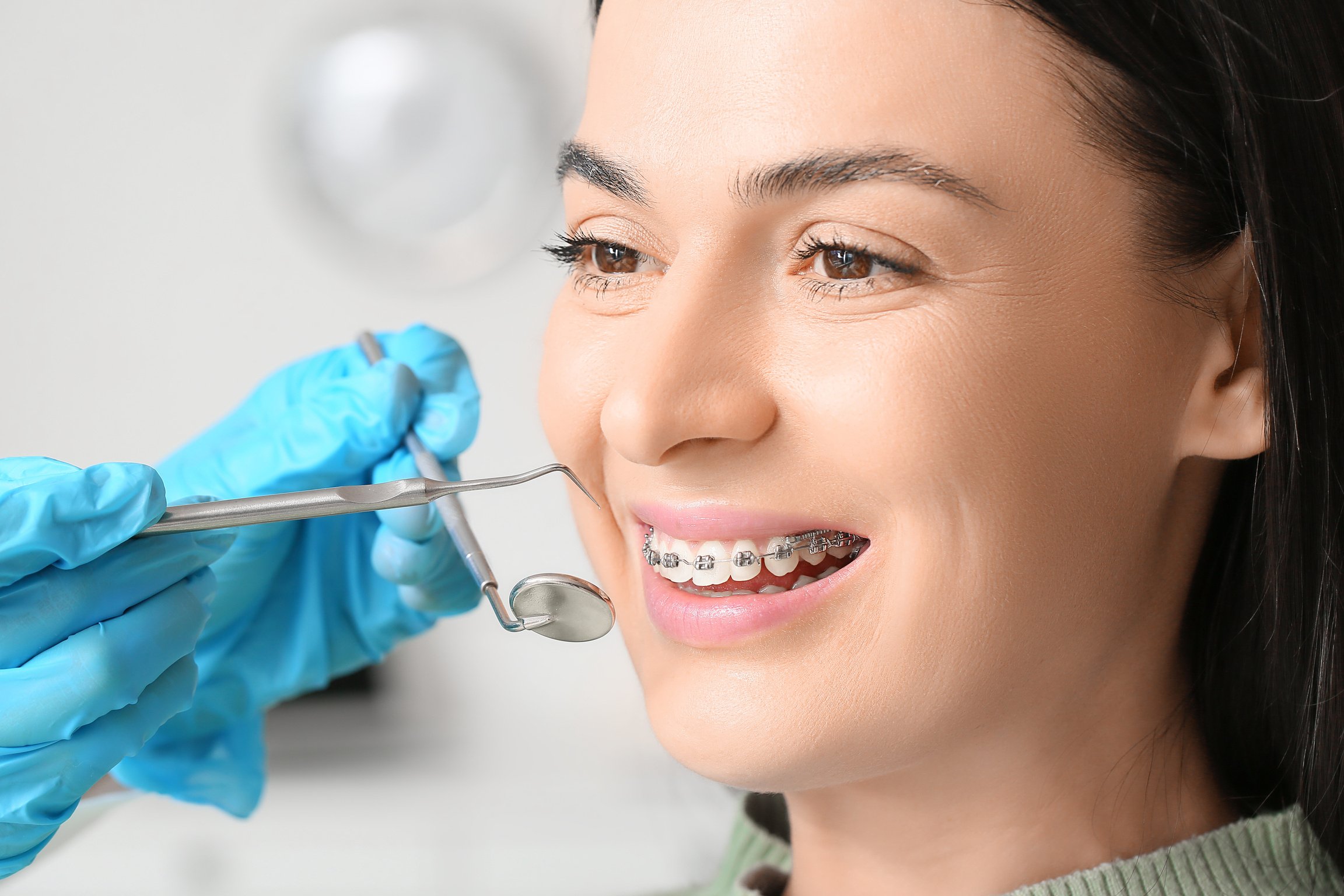 Woman with Dental Braces Visiting Dentist in Clinic, Closeup