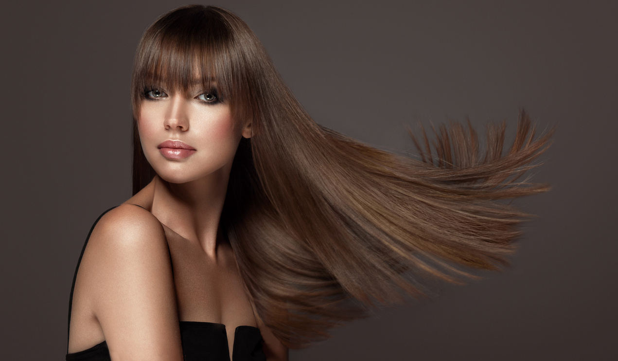 Young, brown haired beautiful model with long, straight, well groomed hair. Hair care and hairdressing art.