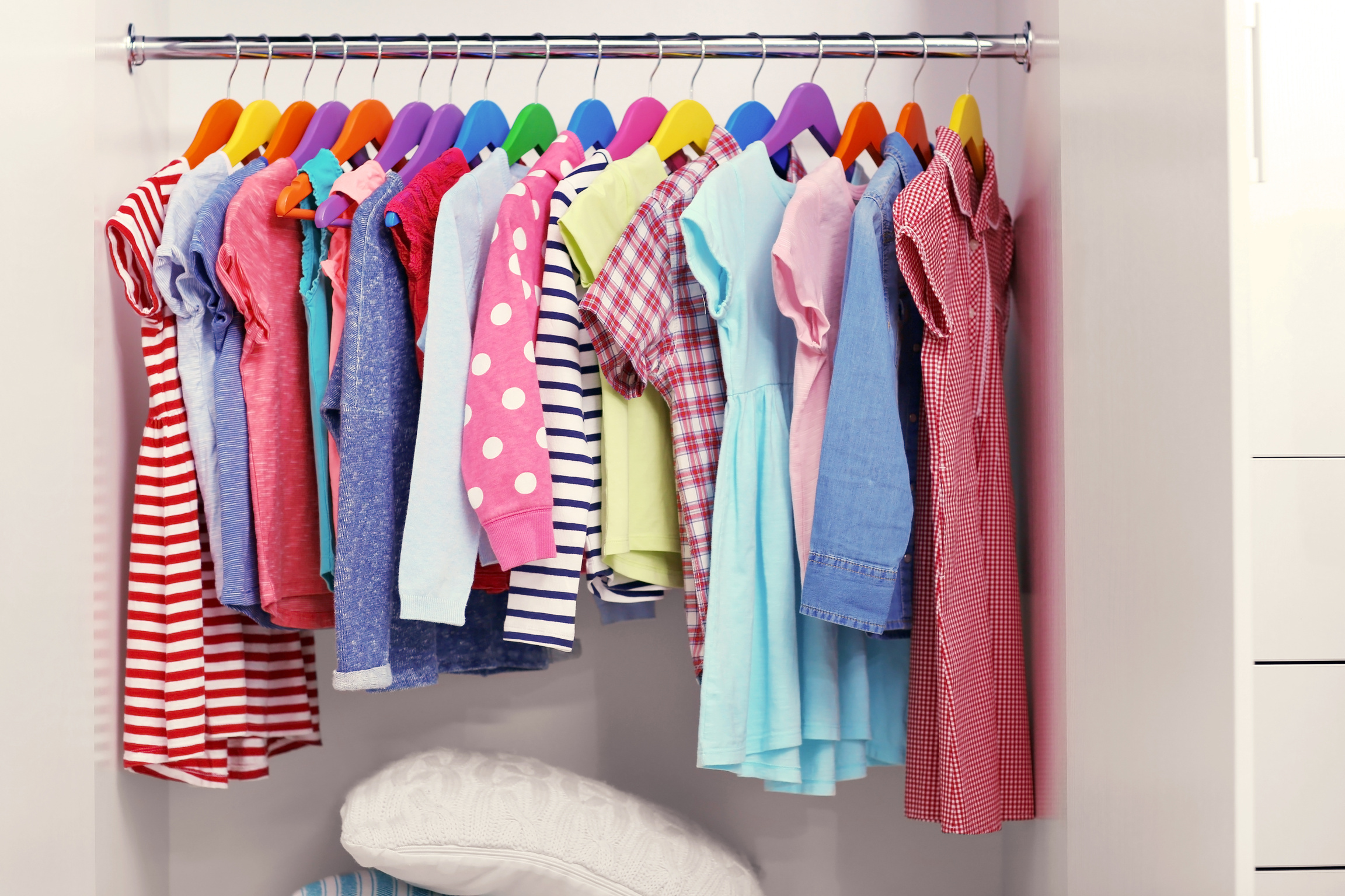 Children Clothes Hanging on Hangers in the Wardrobe